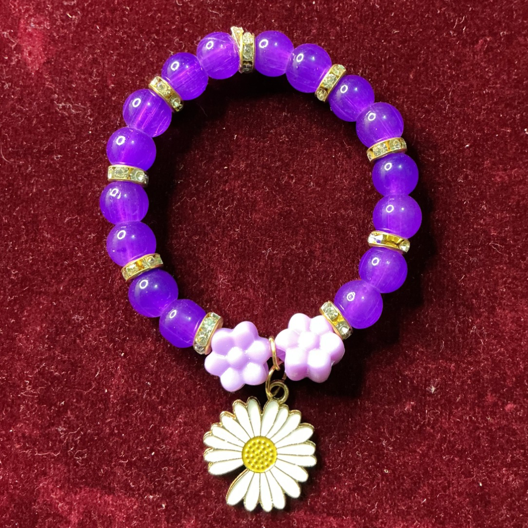 Purple beaded bracelet with a flower charm on a red background