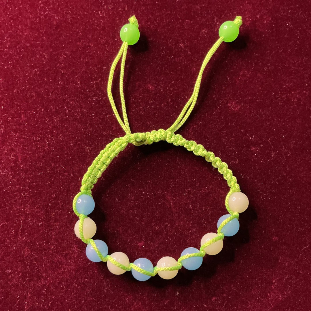 Green bracelet with colorful beads on a maroon background