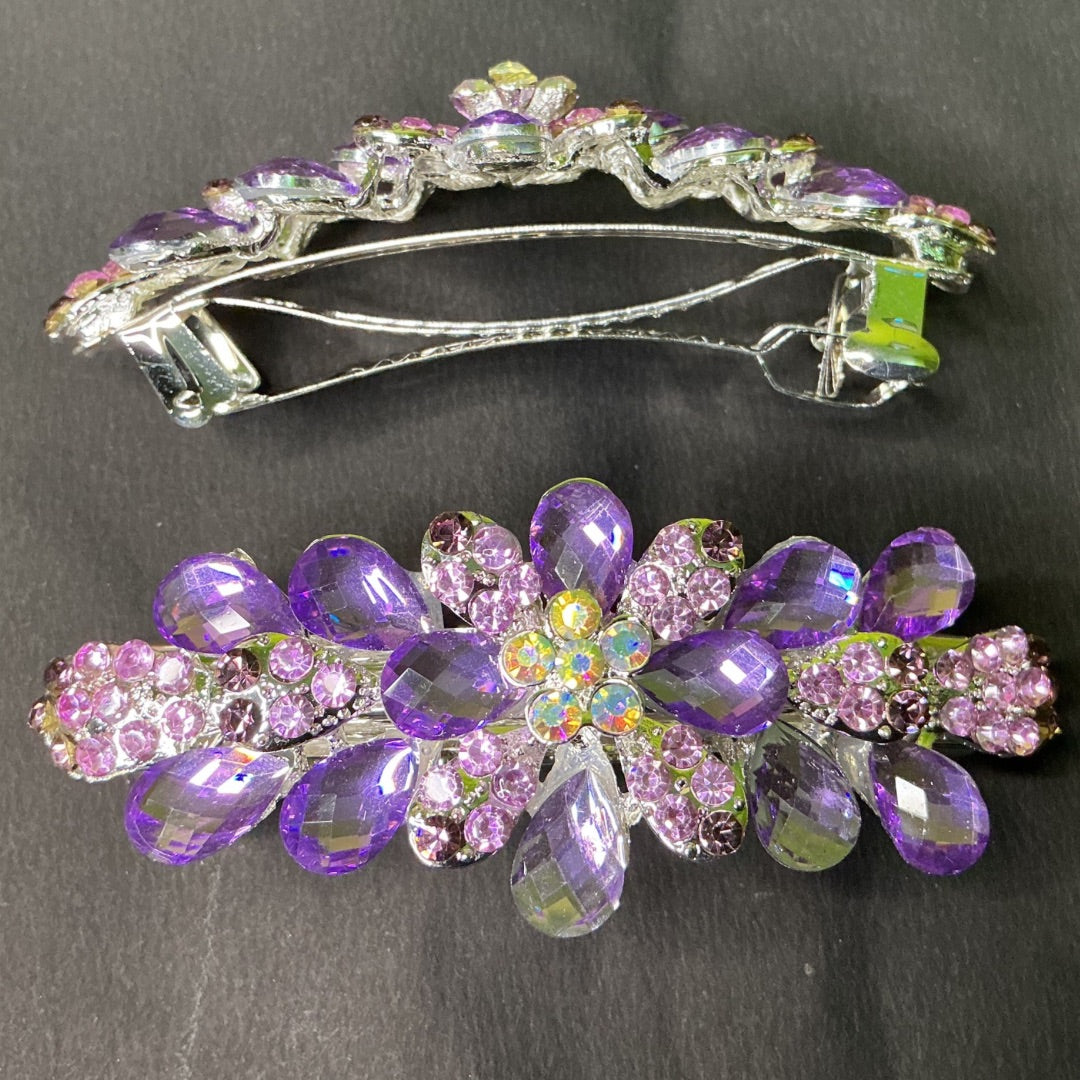 Decorative hair clip with purple and pink gemstones on a dark background
