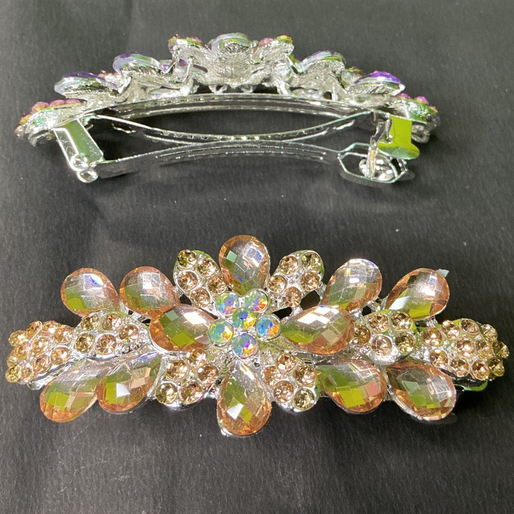 Decorative hair barrettes with gemstone-like embellishments on a dark background