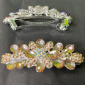 Decorative hair barrettes with gemstone-like embellishments on a dark background